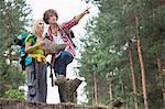 Young hiking couple with map discussing over direction in forest