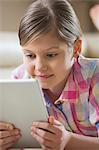 Close-up of girl using digital tablet at home