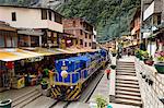 Train crossing the town of Aguas Calientes, Peru, South America