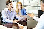 Couple discussing paperwork with advisor