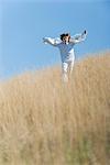 Boy running through tall grass