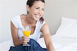 Young woman starting her day with glass of orange juice