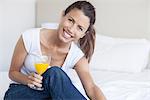 Young woman starting her day with glass of orange juice