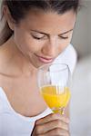 Young woman drinking glass of orange juice