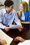 Couple reviewing paperwork in meeting with advisor