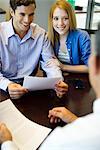 Couple reviewing paperwork in meeting with advisor