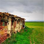 Abandoned house in disrepair in field