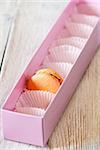 Delicious last orange macaron in a pink box.