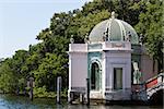 Ornate waterfront building in a garden