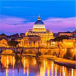 Night view of old roman Bridge of Hadrian and St. Peter's cathedral in Vatican City Rome Italy.