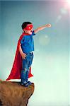 superhero boy child standing on a cliff edge