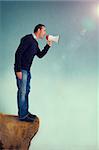 man with a loudhailer or megaphone shouting from edge of a cliff