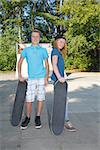 Cool young boy and girl outdoor with skateboard