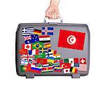 Used plastic suitcase with lots of small stickers, large sticker of Tunisia