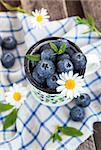 Fresh blueberry in the mug on wooden table