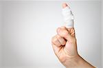 Injured painful finger with white gauze bandage