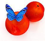 Blue butterflys on a fresh peaches on a white background