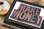 make money online concept - words in vintage letterpress wood type on a digital tablet with a cup of coffee