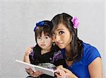 Cute child and young woman reading a story