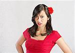 Single disgusted Asian female in red dress