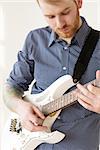 Handsome man playing on guitar