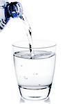 filling a glass with water trough blue bottle on white background