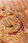 Whole grain bagel with bacon on wooden background. Culinary bagel eating.