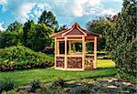 Outdoor wooden gazebo over summer landscape background