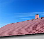 roof with brown tiles on a background of blue sky, new roof