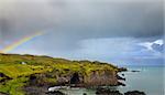 Scenic view of western Icelandic coast with stormy skies and rainbow