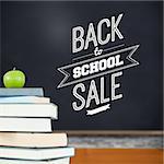 Back to school sale message against green apple on pile of books in classroom