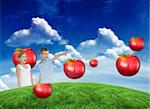 Young boy showing something to his sister against green field under blue sky