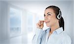 Call center agent looking upwards while talking against bright white hall with columns