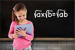 Cute girl using tablet against blackboard on wall