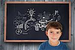 Cute boy smiling against blackboard on wooden board