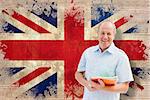 Mature student holding notebooks against union jack flag in grunge effect