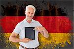 Mature student showing tablet pc against germany flag in grunge effect