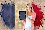 Young pretty student showing tablet pc against france flag in grunge effect
