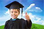 Cute pupil in graduation robe against green hill under blue sky