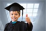 Cute pupil in graduation robe against room with large windows showing city