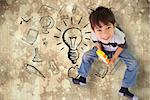 Cute boy sitting with building blocks against paint splattered paper