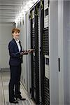Technician working on servers using tablet pc in large data center
