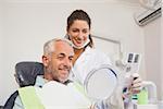 Patient admiring his new smile in the mirror at the dental clinic