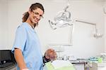 Dentist smiling at camera with patient in the chair at the dental clinic