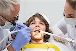 Pediatric dentist and assistant examining a little boys teeth  at the dental clinic