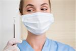 Dentist in surgical mask holding dental explorer at the dental clinic