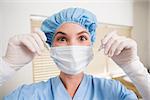 Dentist in surgical mask and cap holding dental tools at the dental clinic