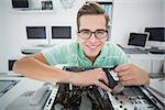 Technician working on broken computer  in his office