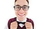 Nerdy hipster fixing his bow tie on white background