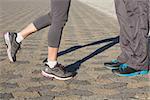 Couple in running shoes facing each other on a sunny day